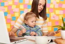 portrait-serious-dark-haired-woman-accountant-wearing-striped-tshirt-sitting-table-posing-against-memo-cards-yellow-wall-playing-with-baby-using-calculator_176532-23307-6811648