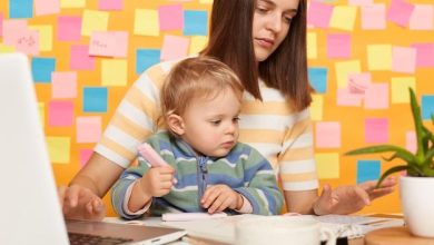 portrait-serious-dark-haired-woman-accountant-wearing-striped-tshirt-sitting-table-posing-against-memo-cards-yellow-wall-playing-with-baby-using-calculator_176532-23307-6811648