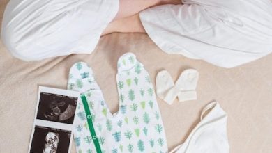 view-anonymous-woman-white-cozy-pajama-sitting-bed-with-ultrasound-image-womb-cute-bodysuit-socks-while-caressing-pregnant-belly-expecting-baby-part-family_8353-12461-5234214